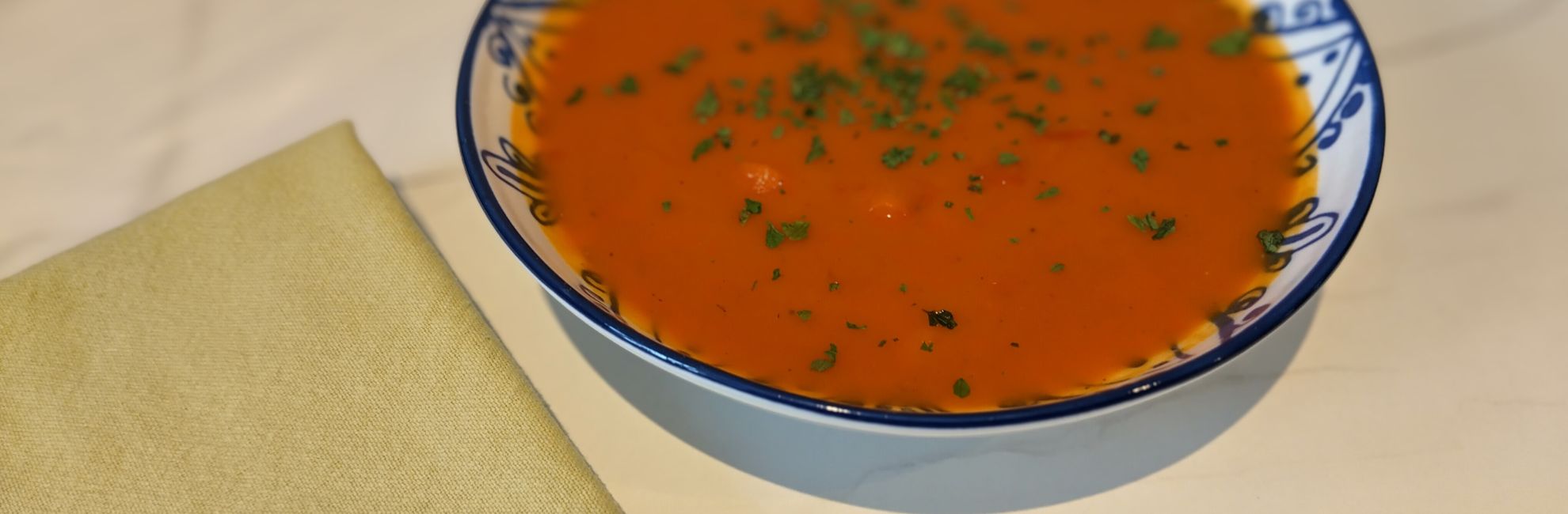Dark orange soup with green flecks of parsley