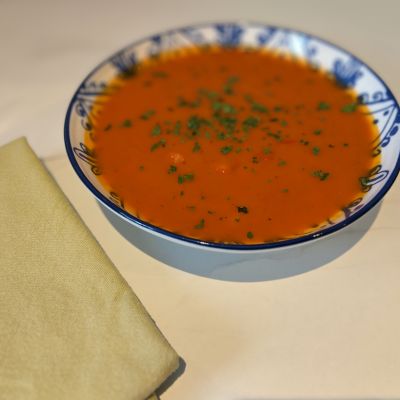Dark orange soup with green flecks of parsley